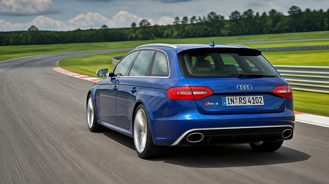 Carro Audi RS4 Avant azul em pista de corrida curvada, capturado de trás e lado direito.